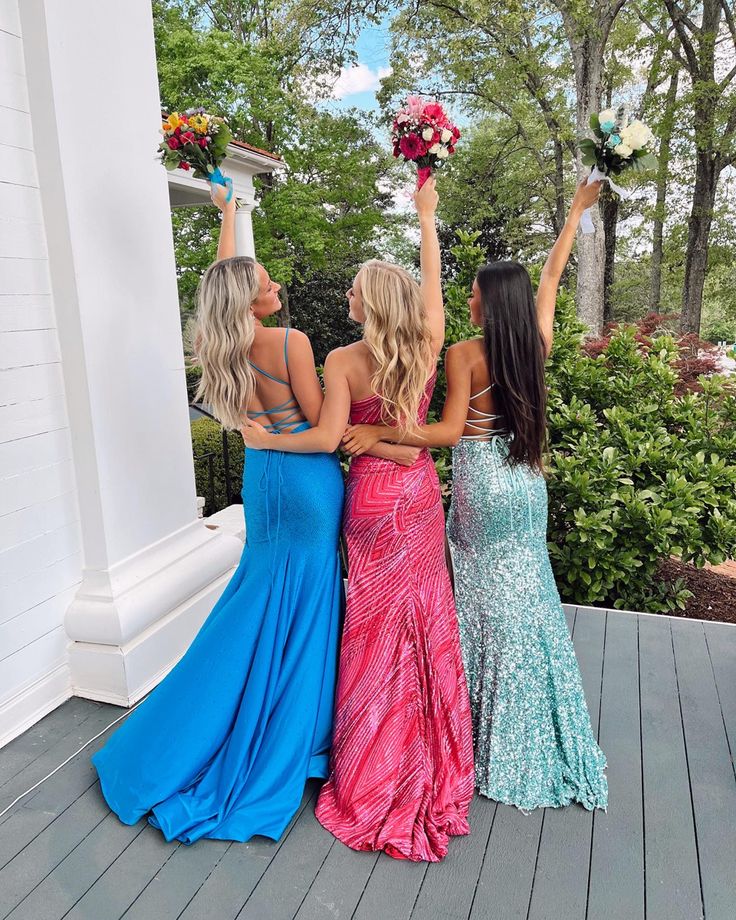 three beautiful women standing next to each other on a porch with their arms in the air