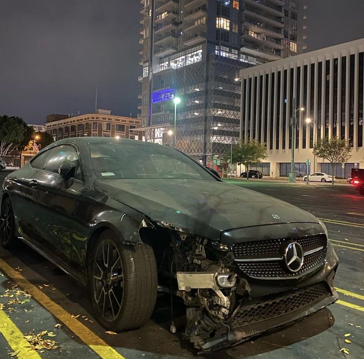 a car that is sitting in the street with it's front end torn off