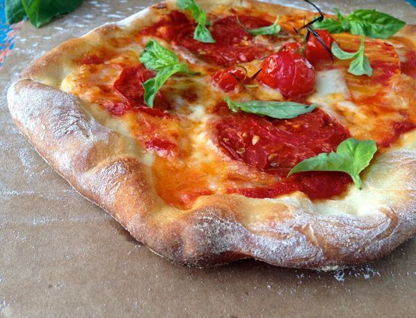 a pizza sitting on top of a piece of cardboard covered in cheese and toppings