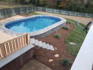 an above ground swimming pool with steps leading up to it and a deck in the background