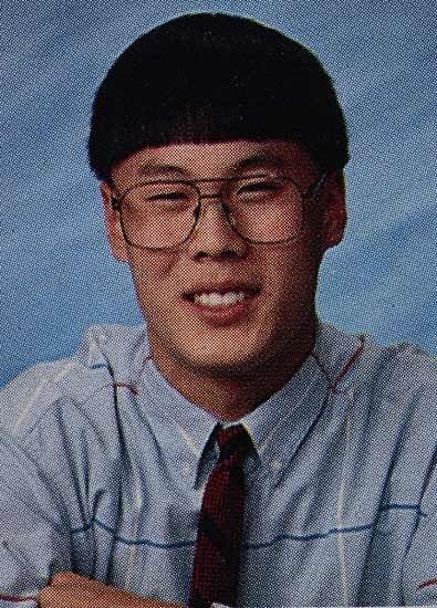 a young man wearing glasses and a tie