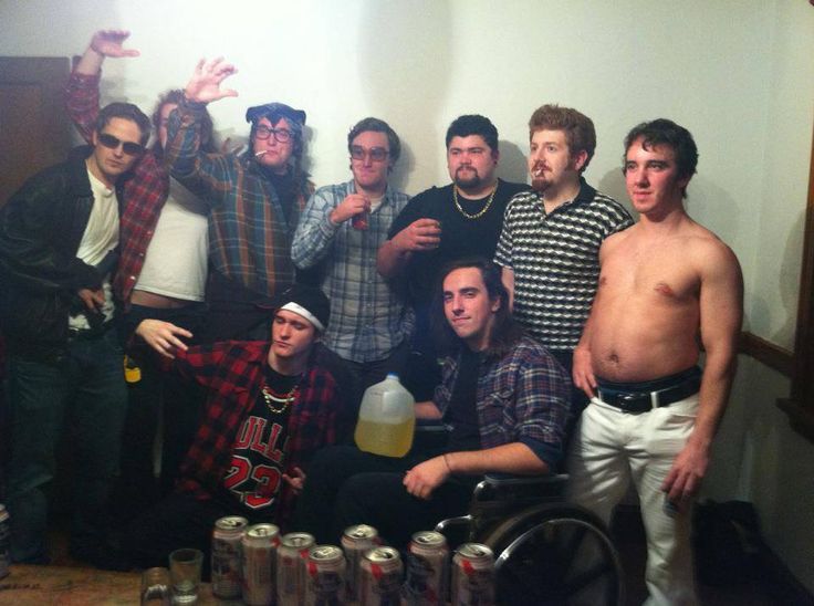 a group of men standing next to each other in front of a table full of drinks