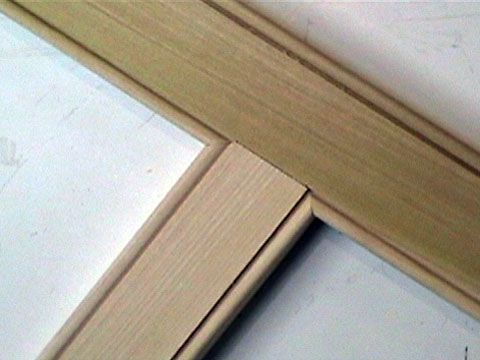 a close up view of the corner of a wooden frame with white paint on it