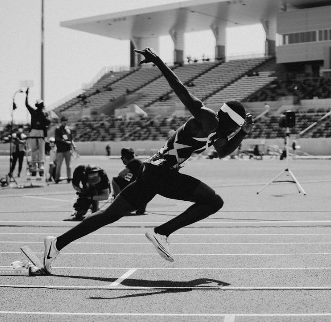 a man jumping in the air on top of a race track