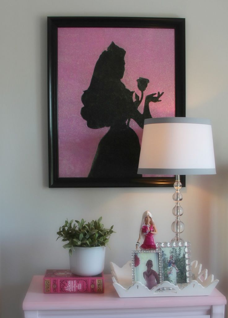 a pink dresser with a lamp on top and a silhouette of a princess holding a flower