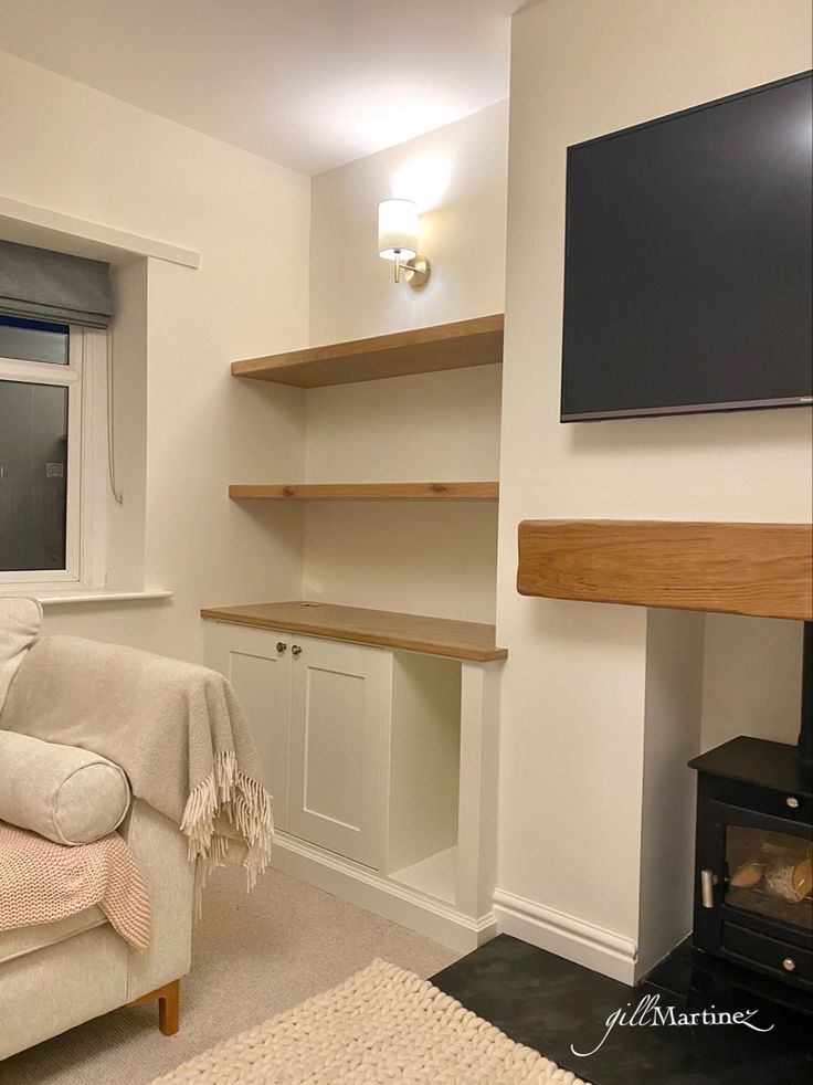 a living room with white walls and wooden shelves