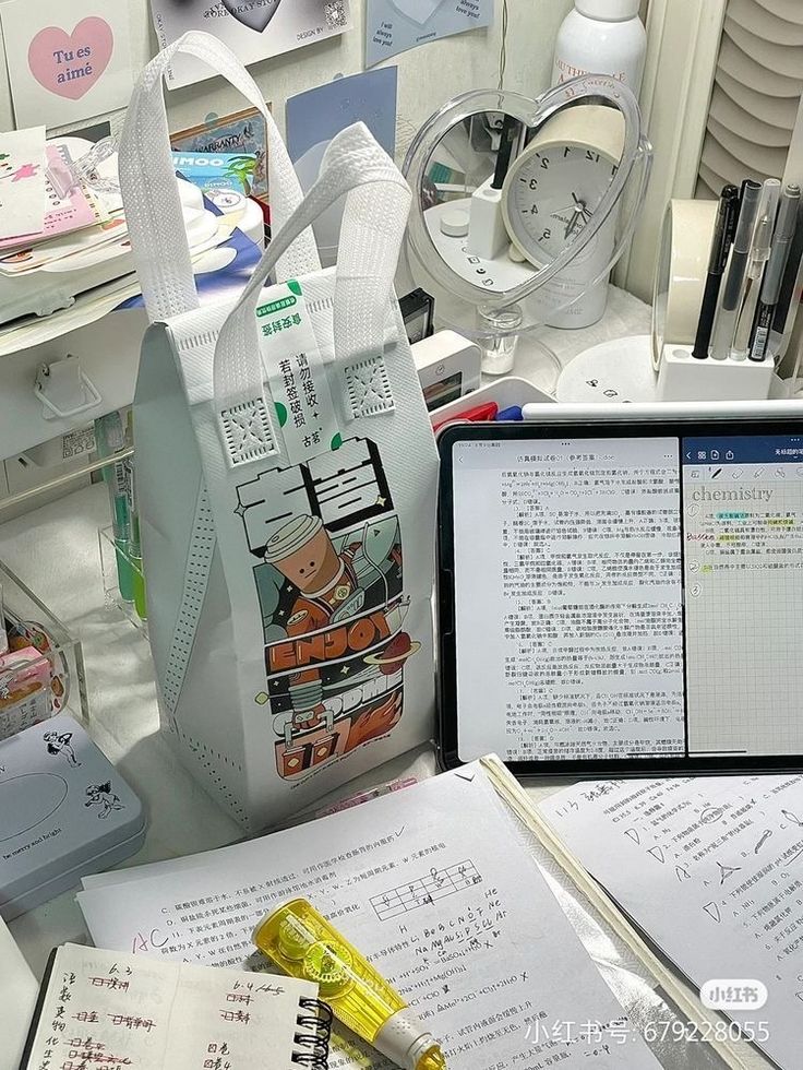 an office desk with various items on it and papers scattered around the desk, including notebooks