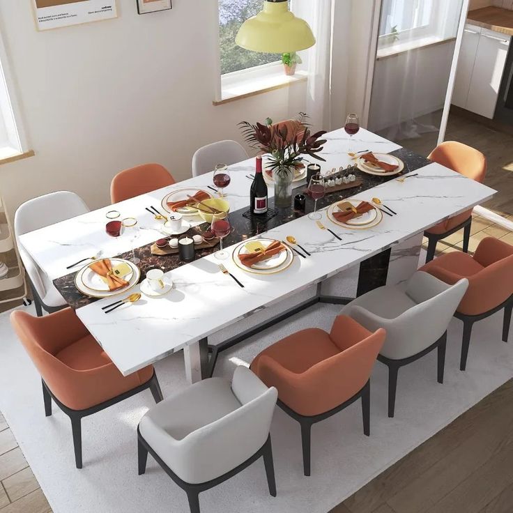 a dining room table with orange chairs and plates on it