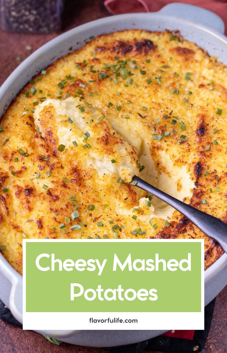 cheesy mashed potatoes in a casserole dish with a serving spoon