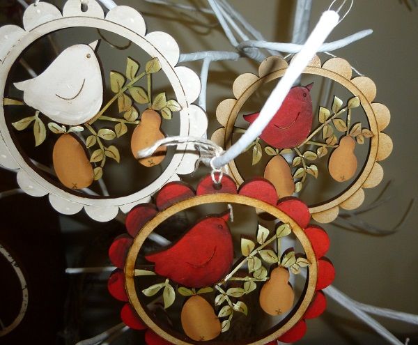 two wooden ornaments with birds and fruit on them