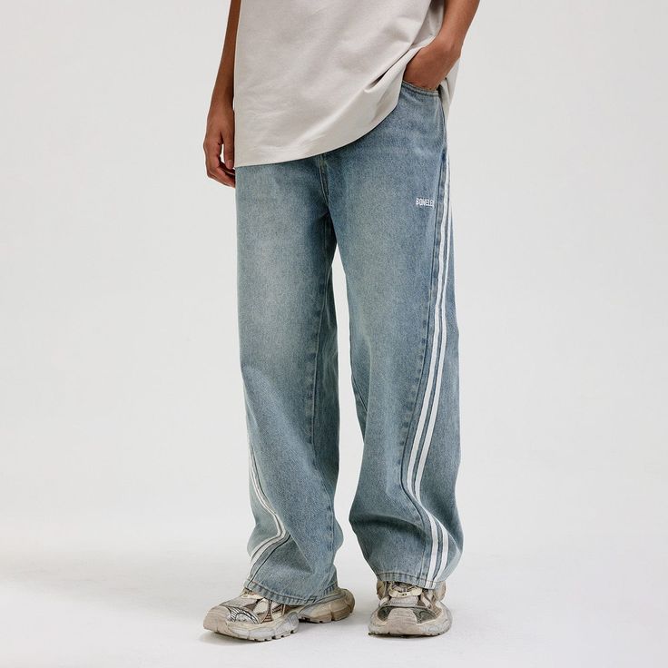 The Washed Striped Wide-Leg Pants seamlessly blend vintage style with contemporary craftsmanship. Featuring an all-over washed and distressed look, these pants are adorned with embroidered logos on each hip. The striking contrast stripes run from the back waist down the front of the legs, enhancing the body’s natural silhouette. Functional front pockets are decorated with rivets, while two back pockets provide additional utility. Crafted from premium fabric, these slightly oversized pants offer Oversized Pants, Striped Wide Leg Pants, Brand Sale, Premium Fabric, Accessories Branding, Rivets, Sale Design, Male Model, Oversized Fits