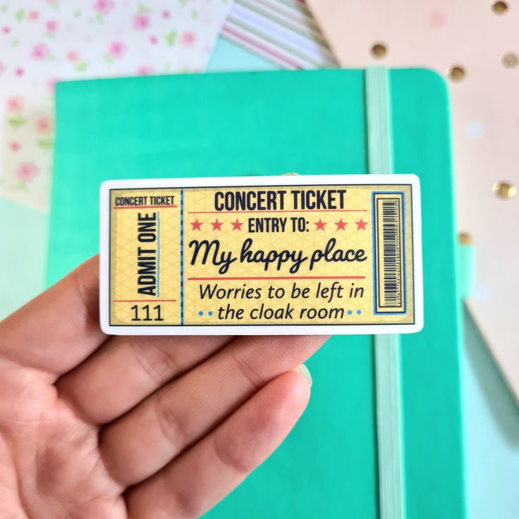 someone is holding up a ticket for the concert at my happy place in the clack room