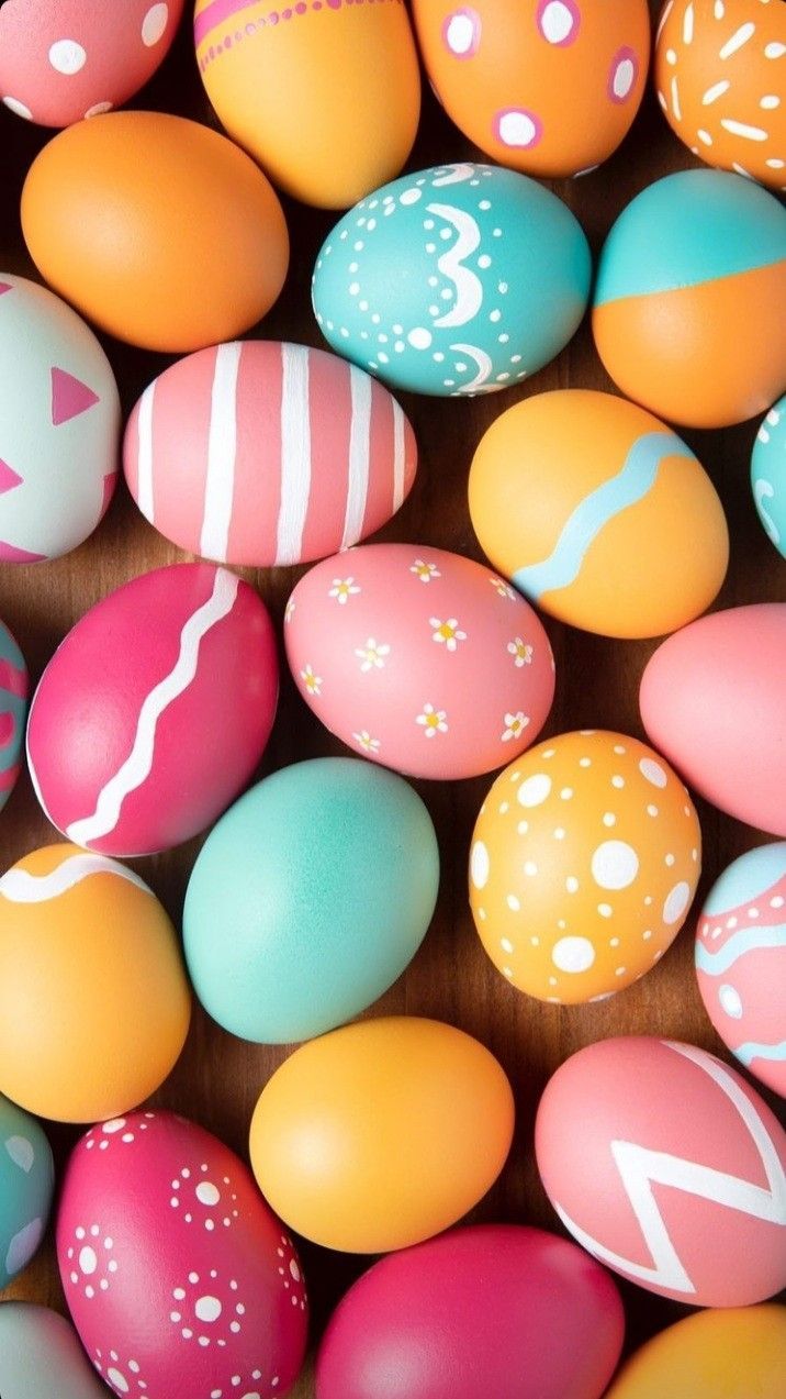 many different colored eggs with designs on them and one has an arrow in the middle