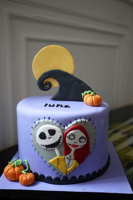 a decorated cake with two skeletons and pumpkins