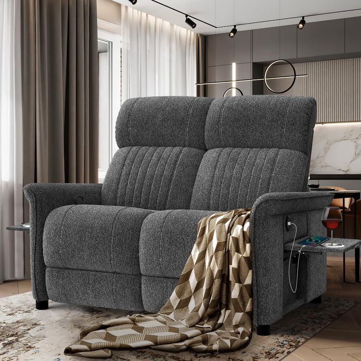 a grey reclining sofa with a blanket on it