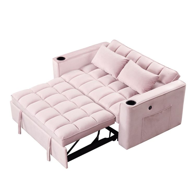 a pink couch with two pillows on it and a cup holder in the middle of the couch