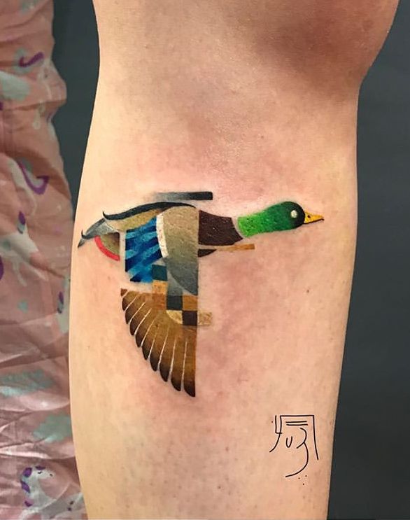 a small tattoo on the leg of a woman with a duck in it's body