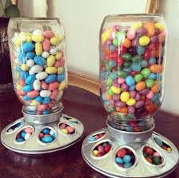 two glass jars filled with candy sitting on top of a table