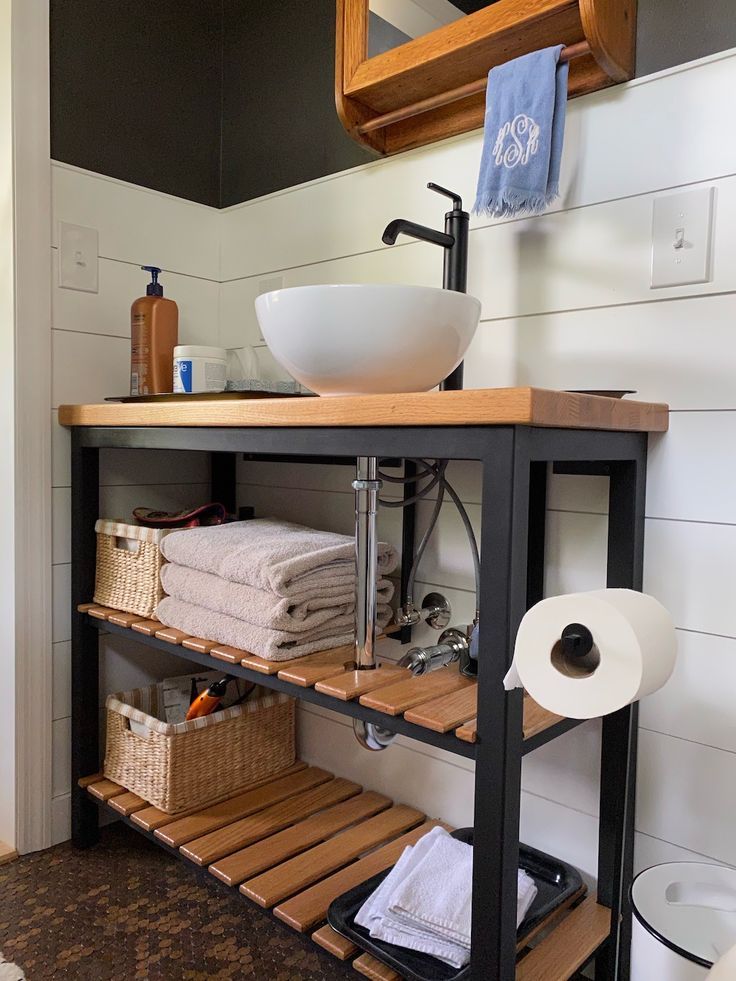 a bathroom with a sink, towel rack and toilet paper on the shelf next to it