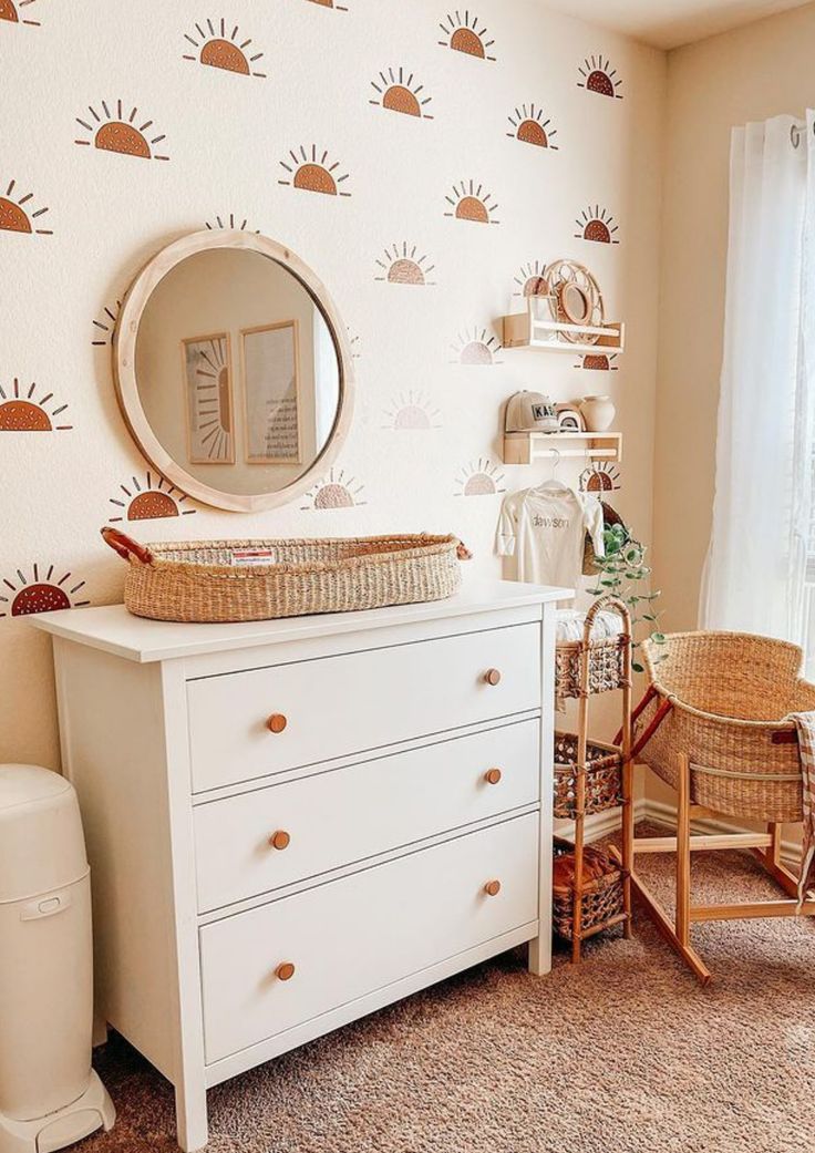 a white dresser sitting next to a window in a room with sun wallpaper on the walls