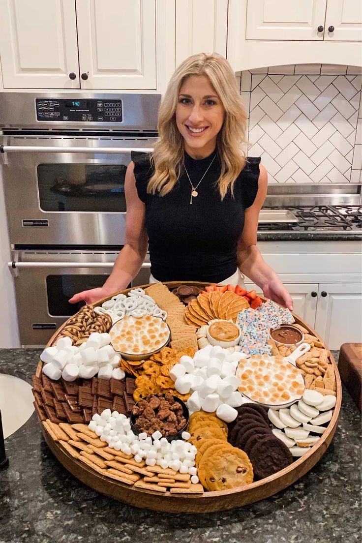 a woman standing in front of a large platter of food