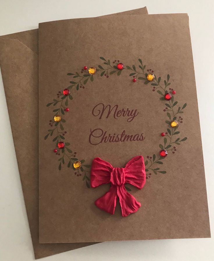 two brown cards with red bows and merry christmas written on the front one has a wreath