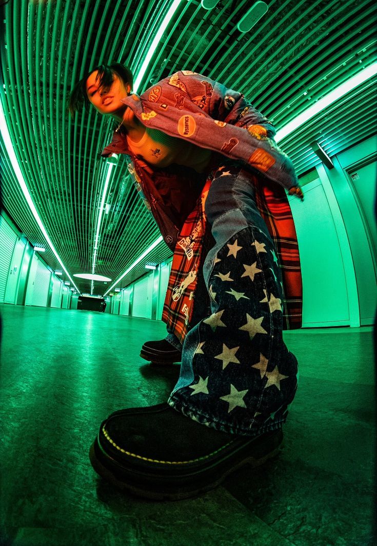 a man sitting on top of a pair of shoes in a green lit tunnel with stars