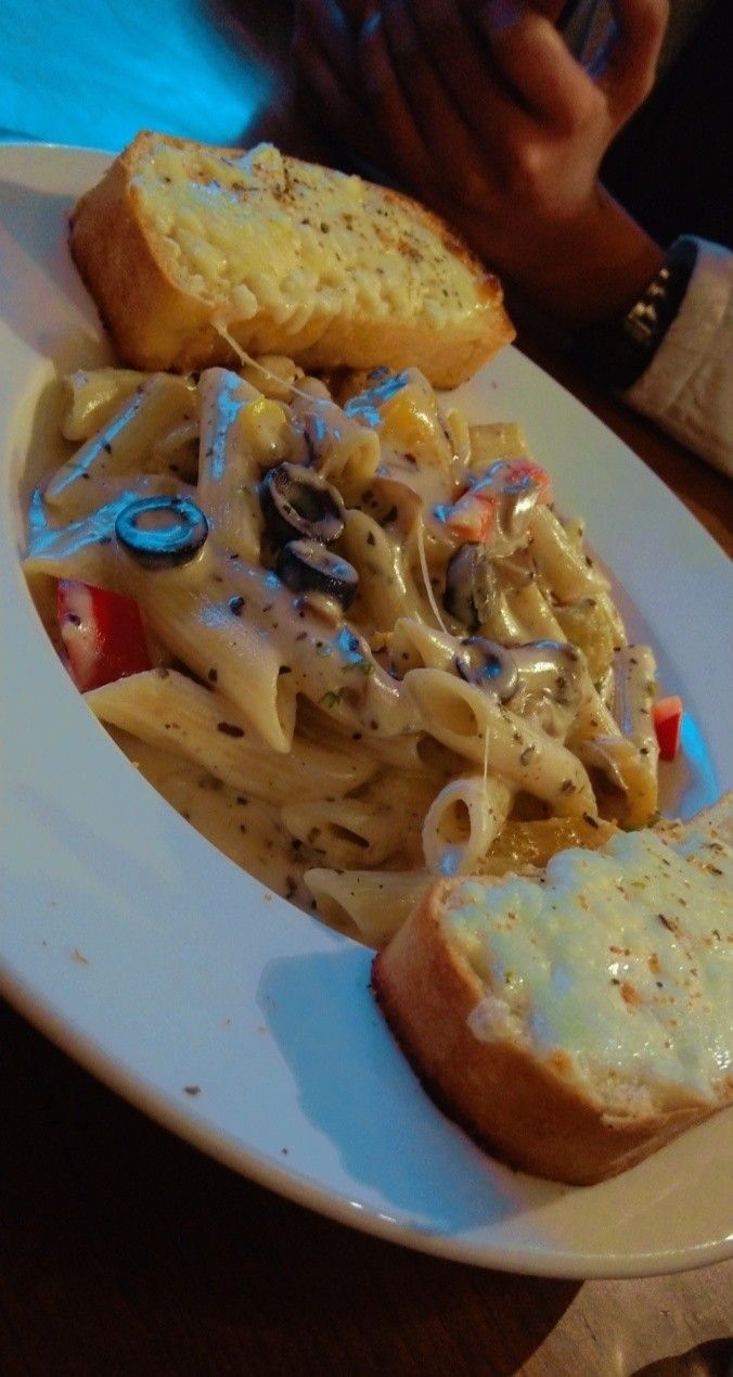 a white plate topped with pasta and bread