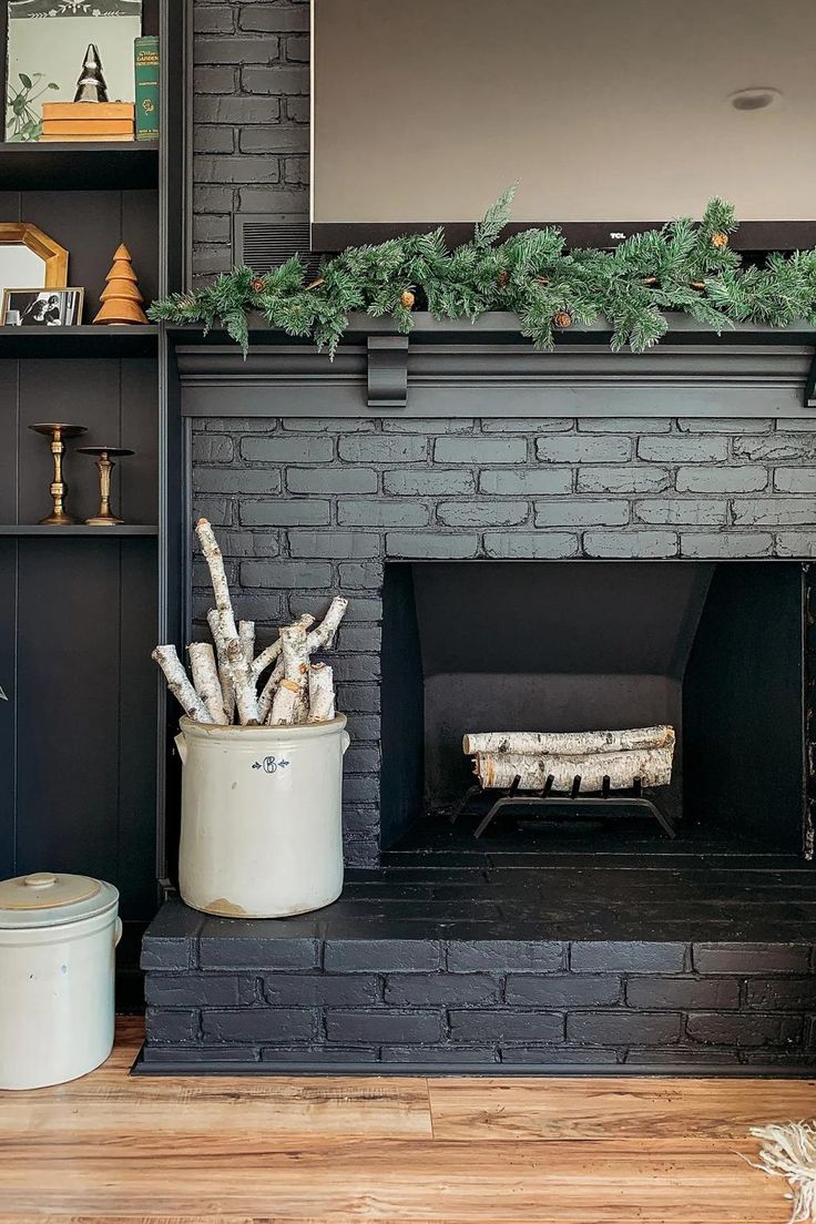 the fireplace is decorated with greenery and other things to put on it's mantle