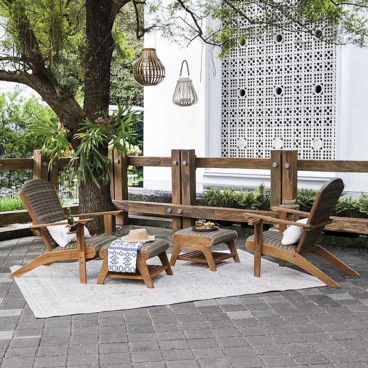 a wooden bench sitting on top of a patio next to a tree