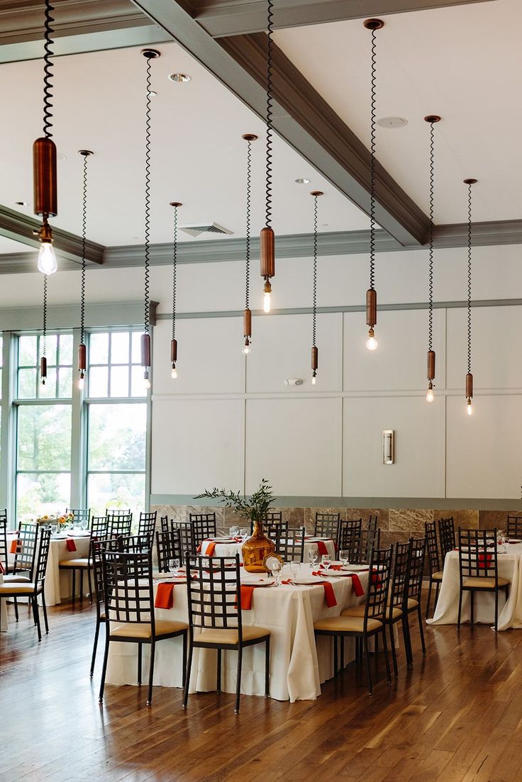 a dining room with tables and chairs set up for an event or function in front of large windows