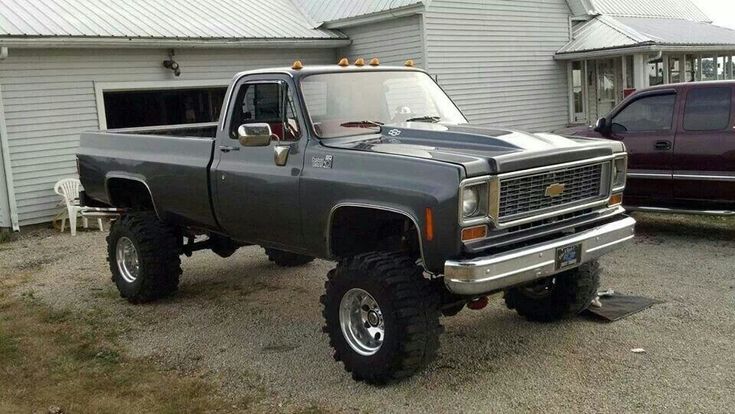 a gray truck parked in front of a white house