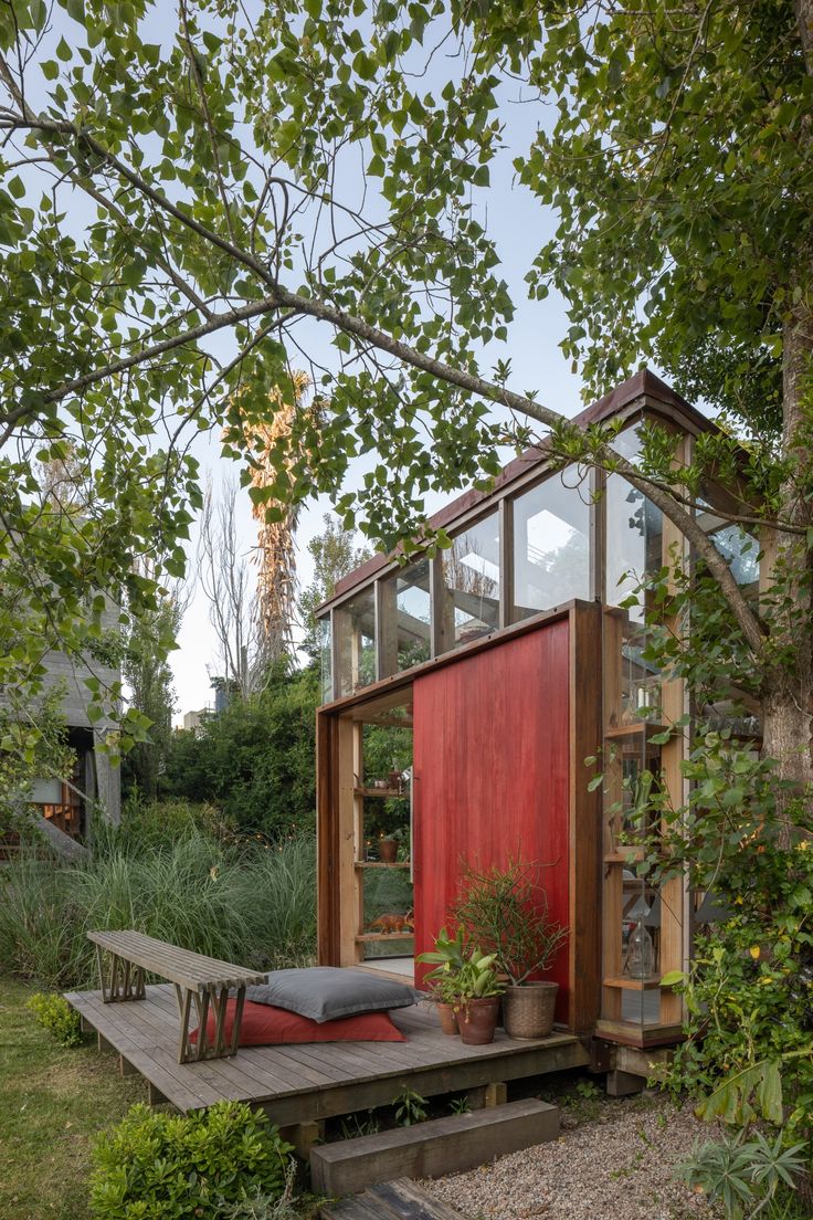 a small red building sitting on top of a wooden platform