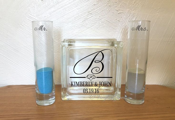 two personalized glass vases sitting next to each other on top of a wooden table