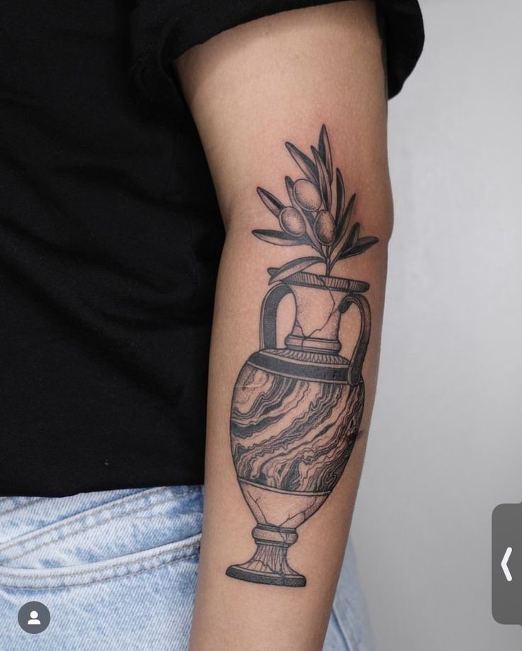 a woman's arm with a vase tattoo on it