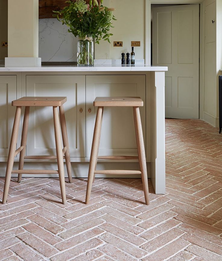 two wooden stools sitting in front of a kitchen island