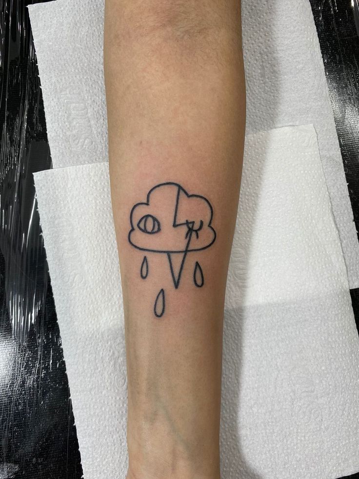 a person's foot with a tattoo on it that has a cloud and rain coming out of it