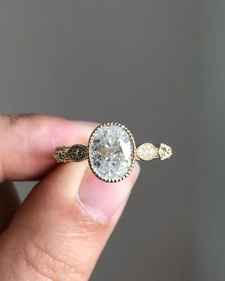 a person holding a ring with a diamond in it's middle and two diamonds on the other side