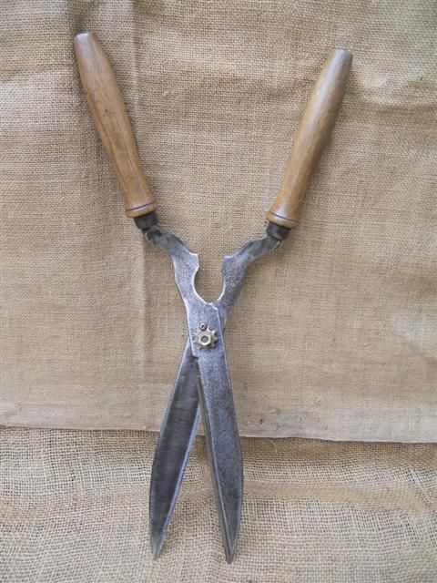 two pairs of scissors sitting on top of a burlocked cloth covered surface