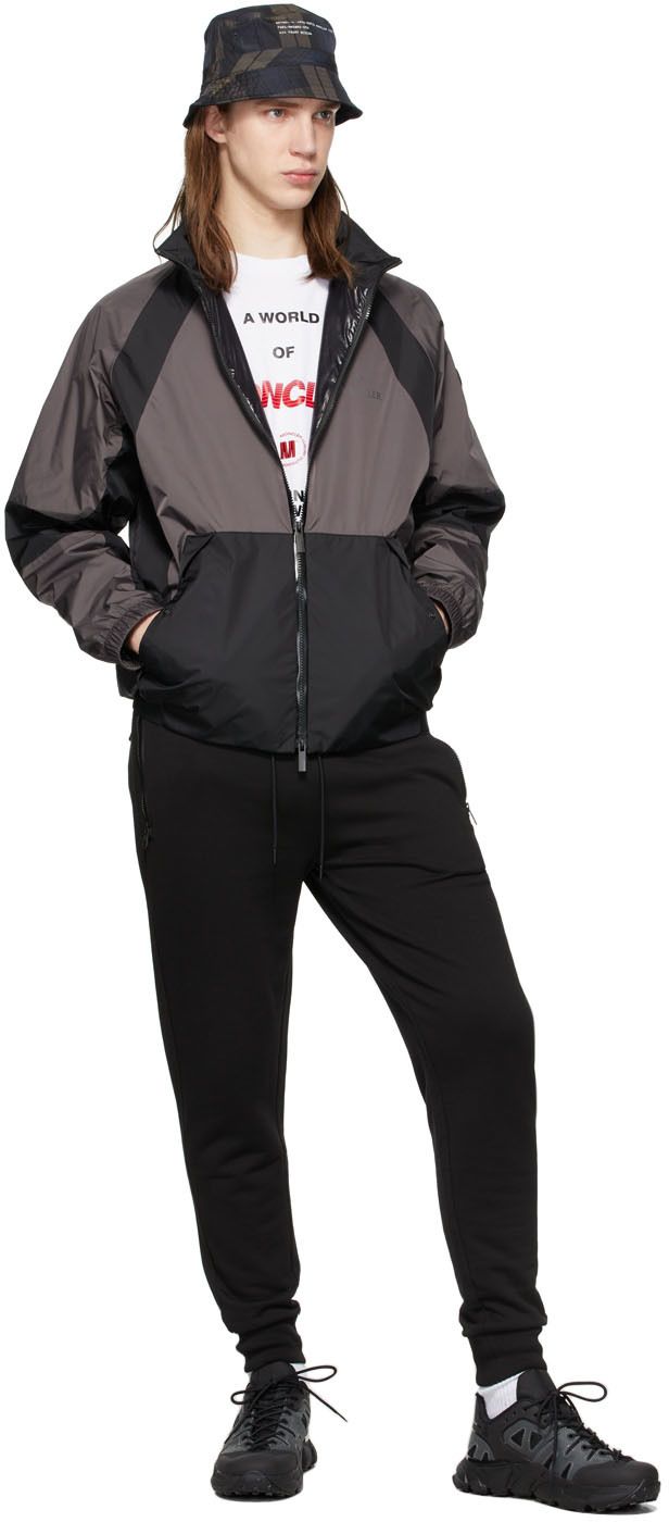 Long sleeve water-repellant paneled nylon taffeta jacket in black and grey featuring reflective logo appliqué at chest and back. · Stand collar · Two-way zip closure · Flap pockets at waist · Rubberized logo patch at sleeve · Elasticized cuffs and hem · Fully lined Supplier color: Grey Black Technical Nylon Windbreaker, Black Technical Windbreaker For Fall, Technical Black Windbreaker For Fall, Black Track Jacket With Zipper For Streetwear, Technical Nylon Track Jacket With Reflective Details, Black Technical Outerwear For Fall, Black Sporty Track Jacket With Side Pockets, Black Nylon Track Jacket For Outdoor, Outdoor Nylon Outerwear With Logo Patch