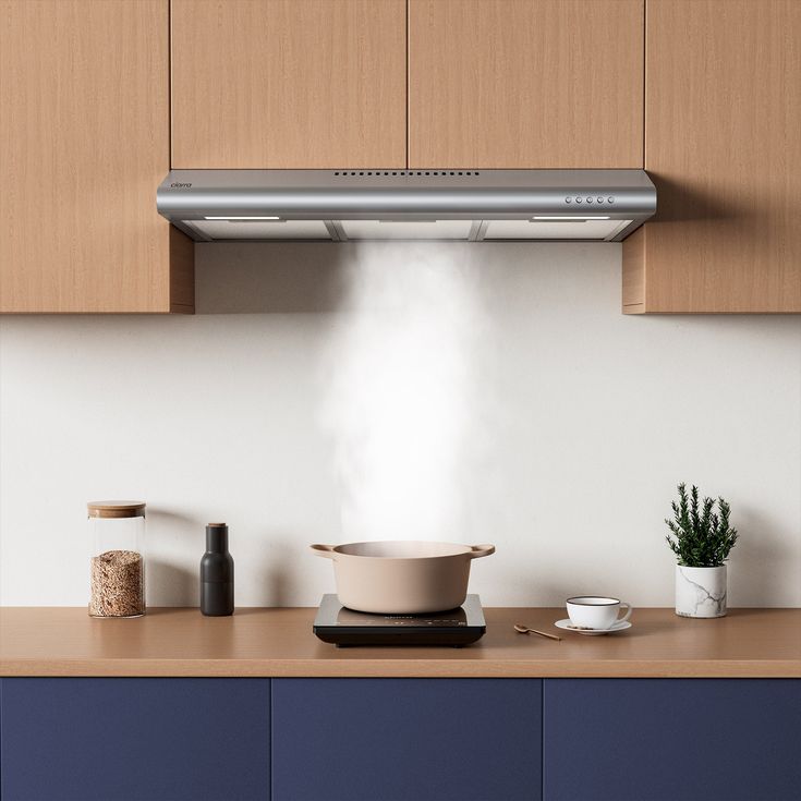 a kitchen with wooden cabinets and an oven hood over the stove top, surrounded by various items on the countertop