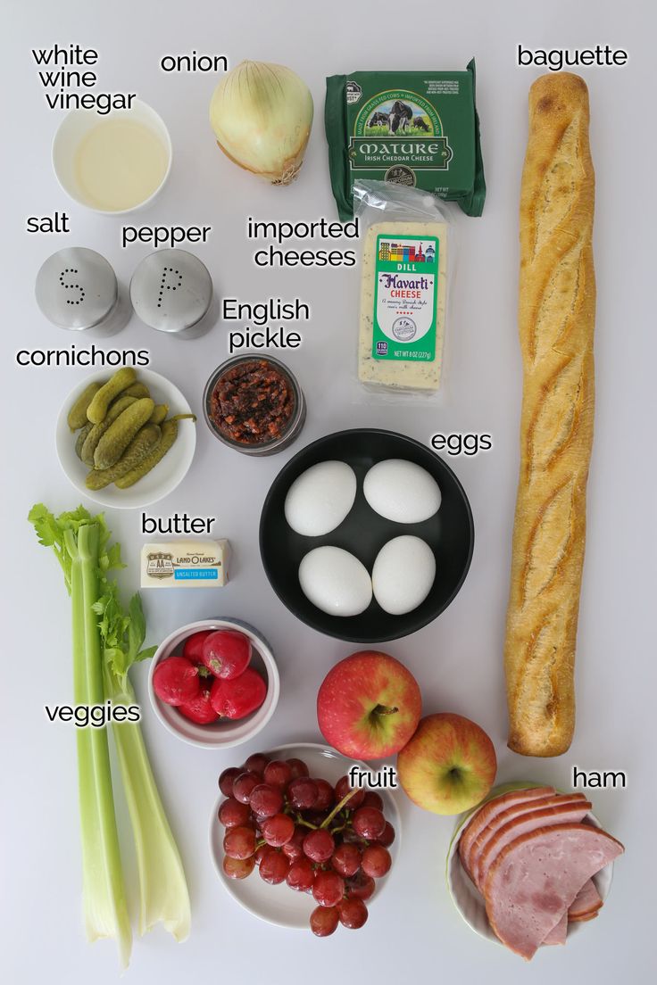 an image of food that includes bread, eggs, grapes and other foodstuffs