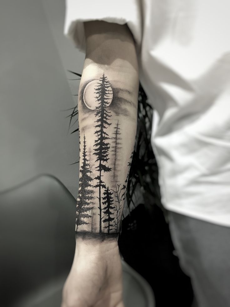 a man's arm with trees and the moon in the sky on his left forearm