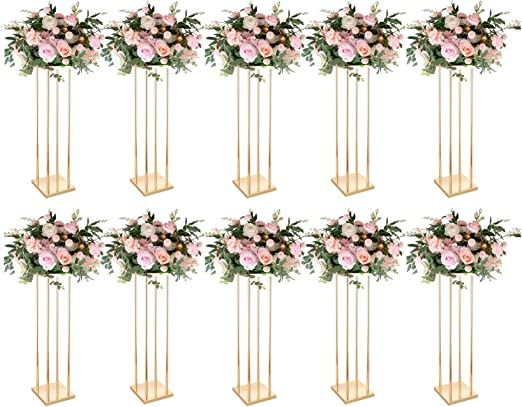 six tall vases with pink flowers and greenery on each side, all in gold