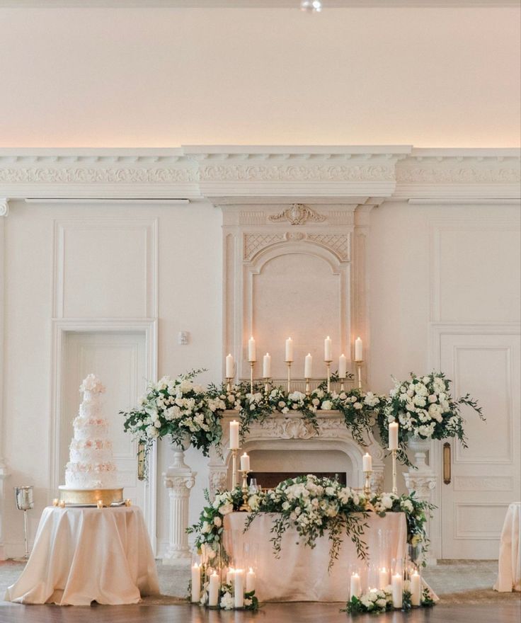 a wedding cake and candles in front of a fireplace