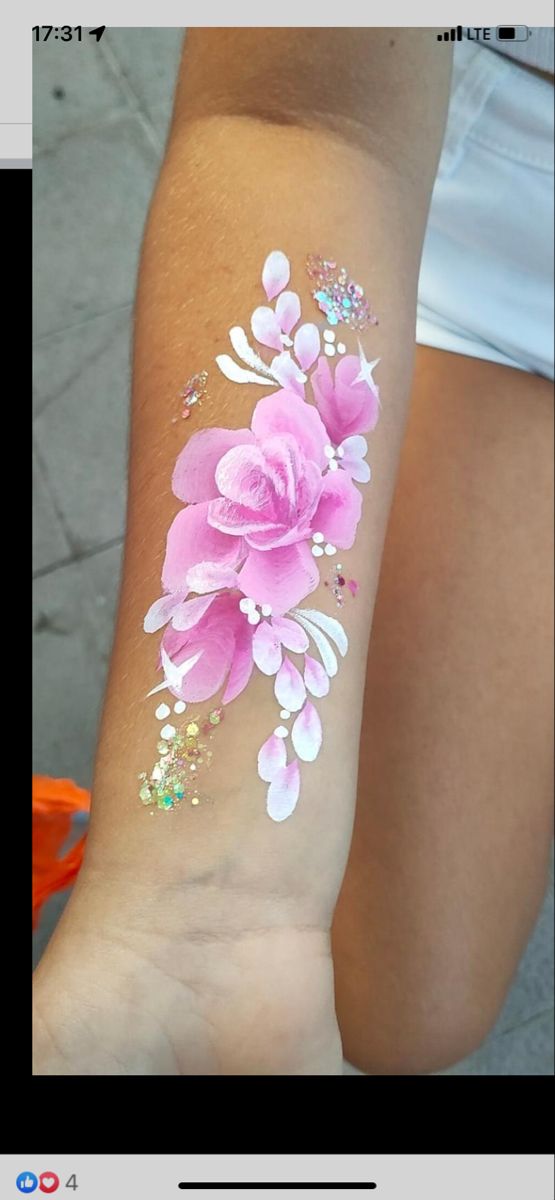 a woman's arm with pink flowers painted on it