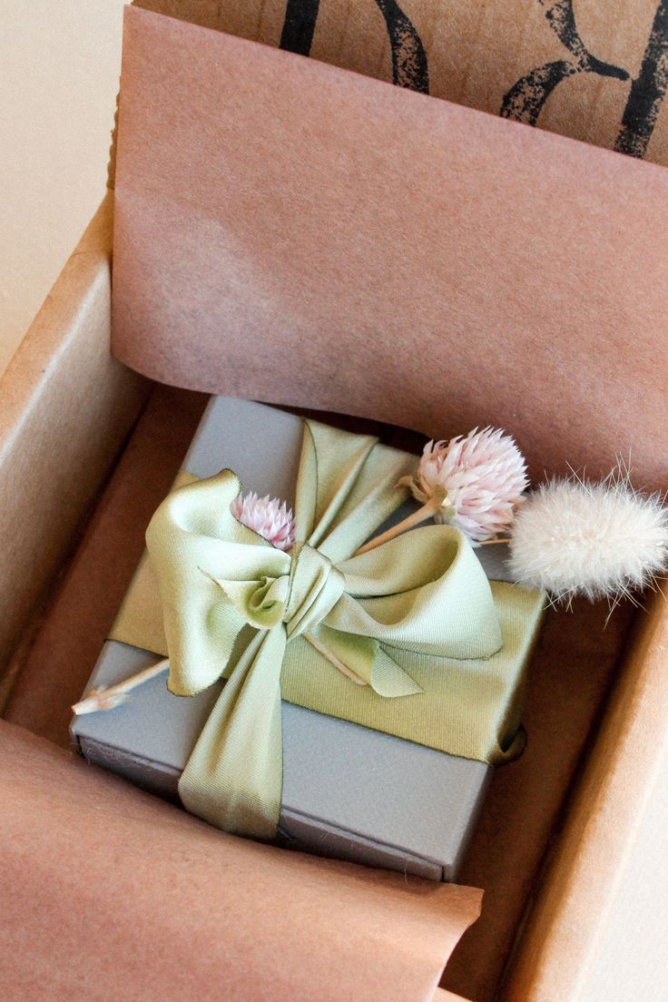 a wrapped present in a box with a pom - pom