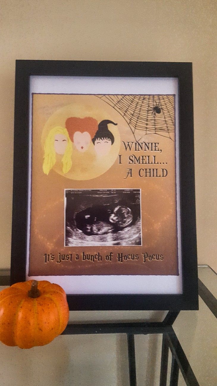 a pumpkin sitting on top of a table next to a framed poster with the words veine i smell, a child