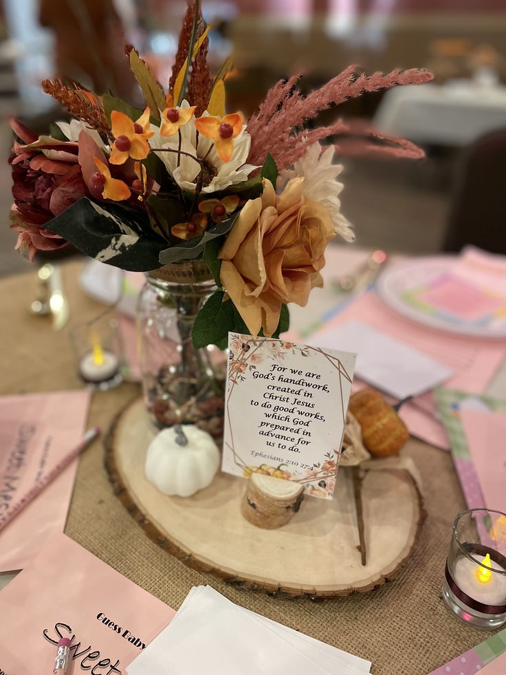 a vase filled with flowers sitting on top of a wooden table next to a note