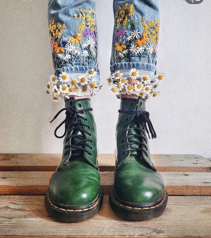 a pair of green boots with daisies on them and laces around the ankles